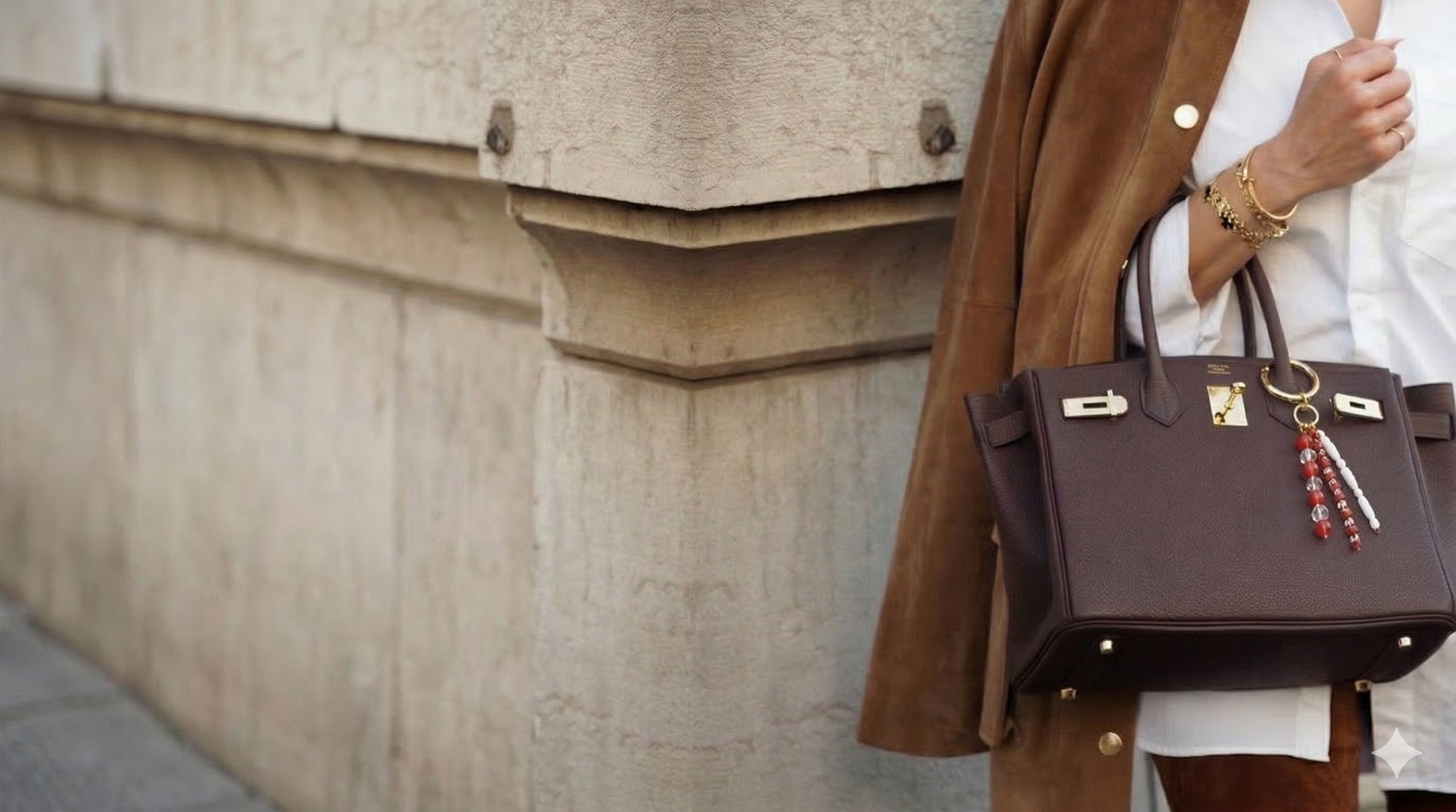 Person holding a brown handbag with a blurred background
