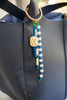 Beaded keychain attached to a black leather bag