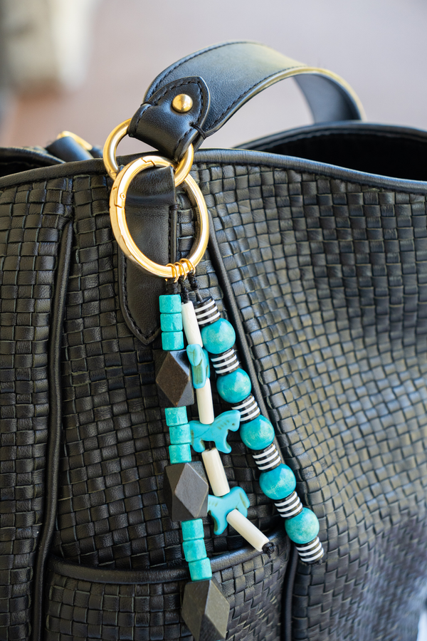 Beaded handbag charm attached to a black handbag
