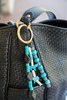 Beaded handbag charm attached to a black handbag