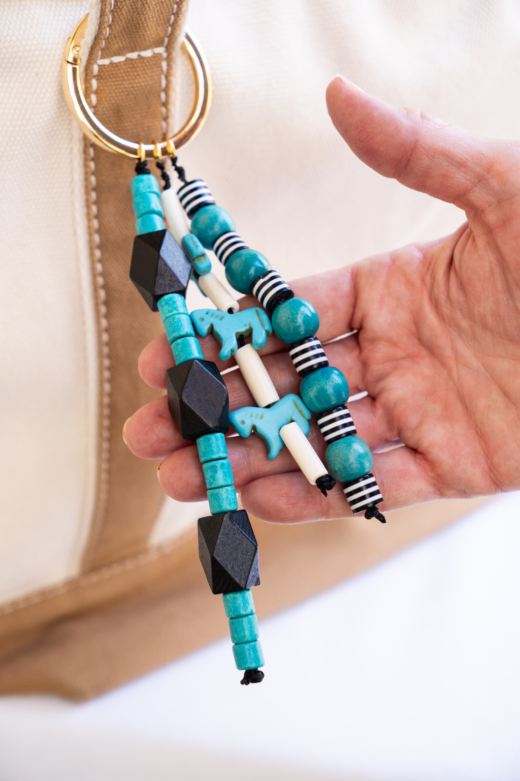 Colorful beaded keychain held by a hand with a blurred background