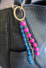 Colorful beaded keychain attached to a black textured bag