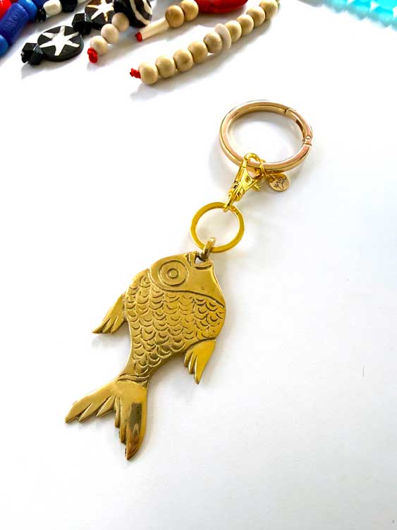Gold fish-shaped keychain on a white background