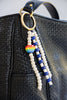 Beaded keychain with rainbow charm attached to a black bag.