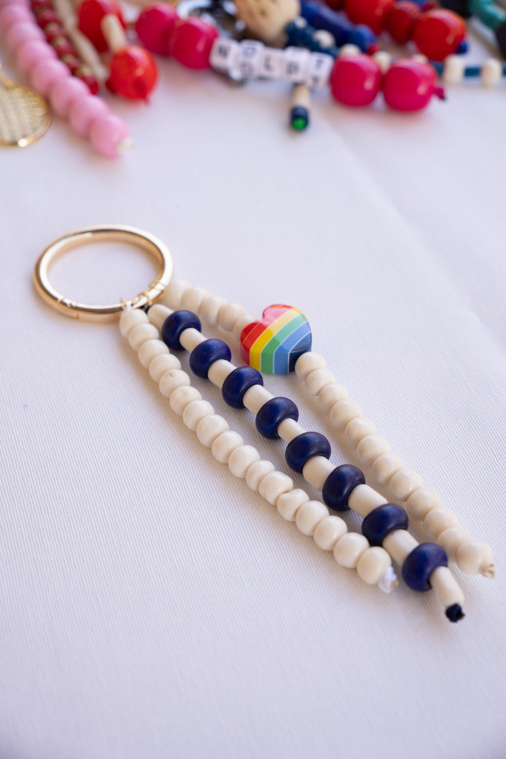 Beaded keychain with rainbow heart charm on a white background