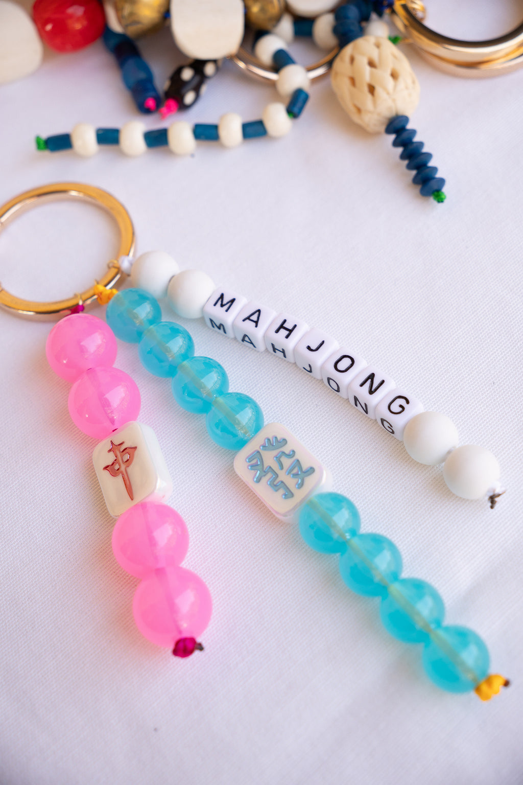Colorful beaded keychains with 'Mahjong' text on a white background