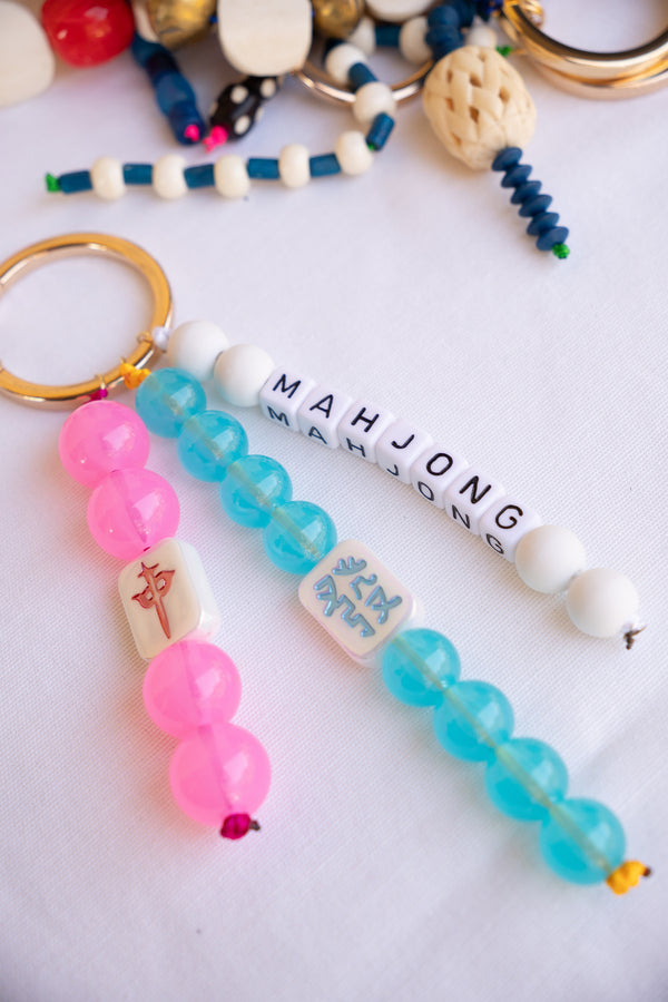 Colorful beaded keychains with 'Mahjong' text on a white background