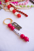 Bag Charm with beads and a bottle opener on a white background